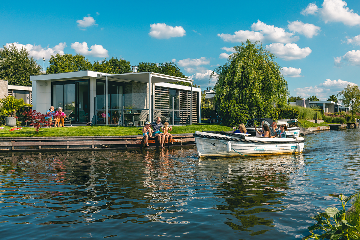 Fluss mit Boot und im Hintergrund ein Ferienhaus